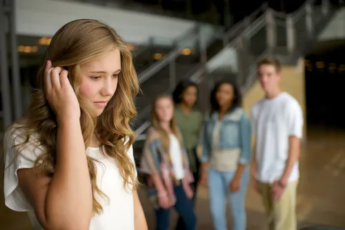 sad young woman with other youth in the background