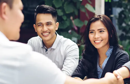 group of young adults sitting at a table together
