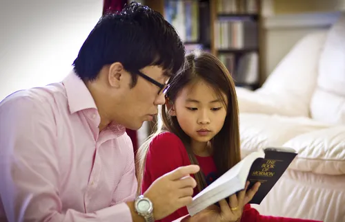 Father and daughter studying scriptures
