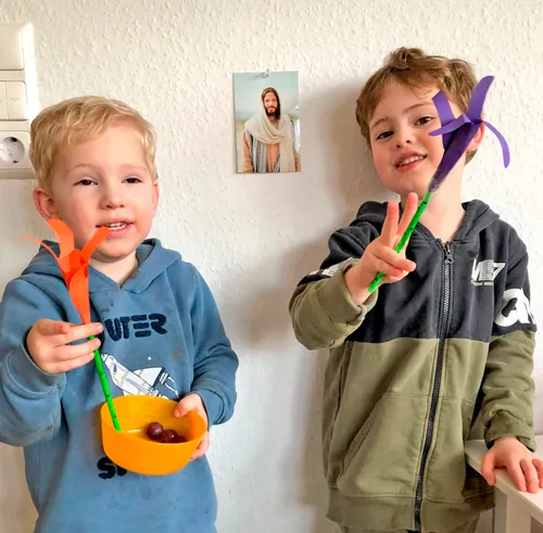 Image of two boys holding paper Easter lilies