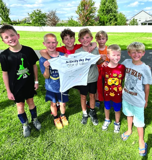 Group of boys holding a T-shirt made into a title of liberty flag