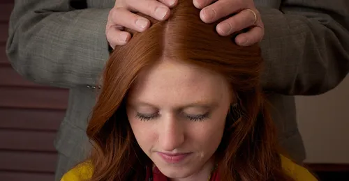 young woman receiving a blessing