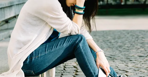 young woman sitting with head down