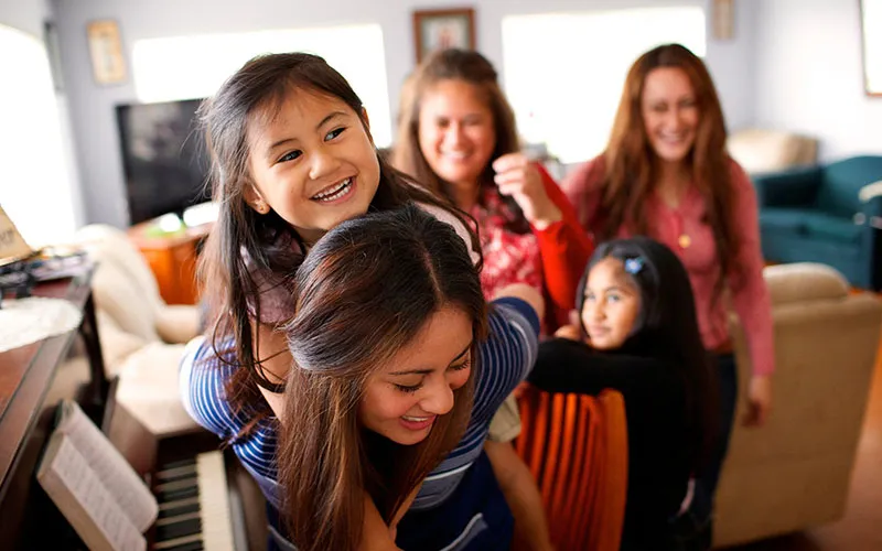 A young family of women play together in their home