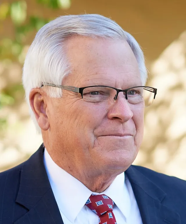 A senior missionary models appropriate jackets and dress and he smiles and talks to someone off camera.