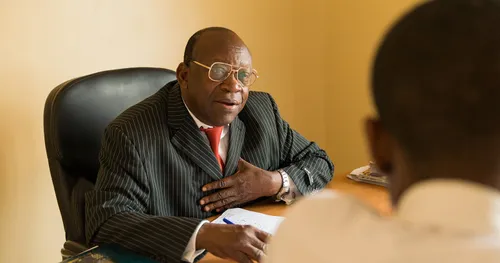 主教在辦公室與一位男青年談話