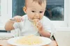 infant eating noodles