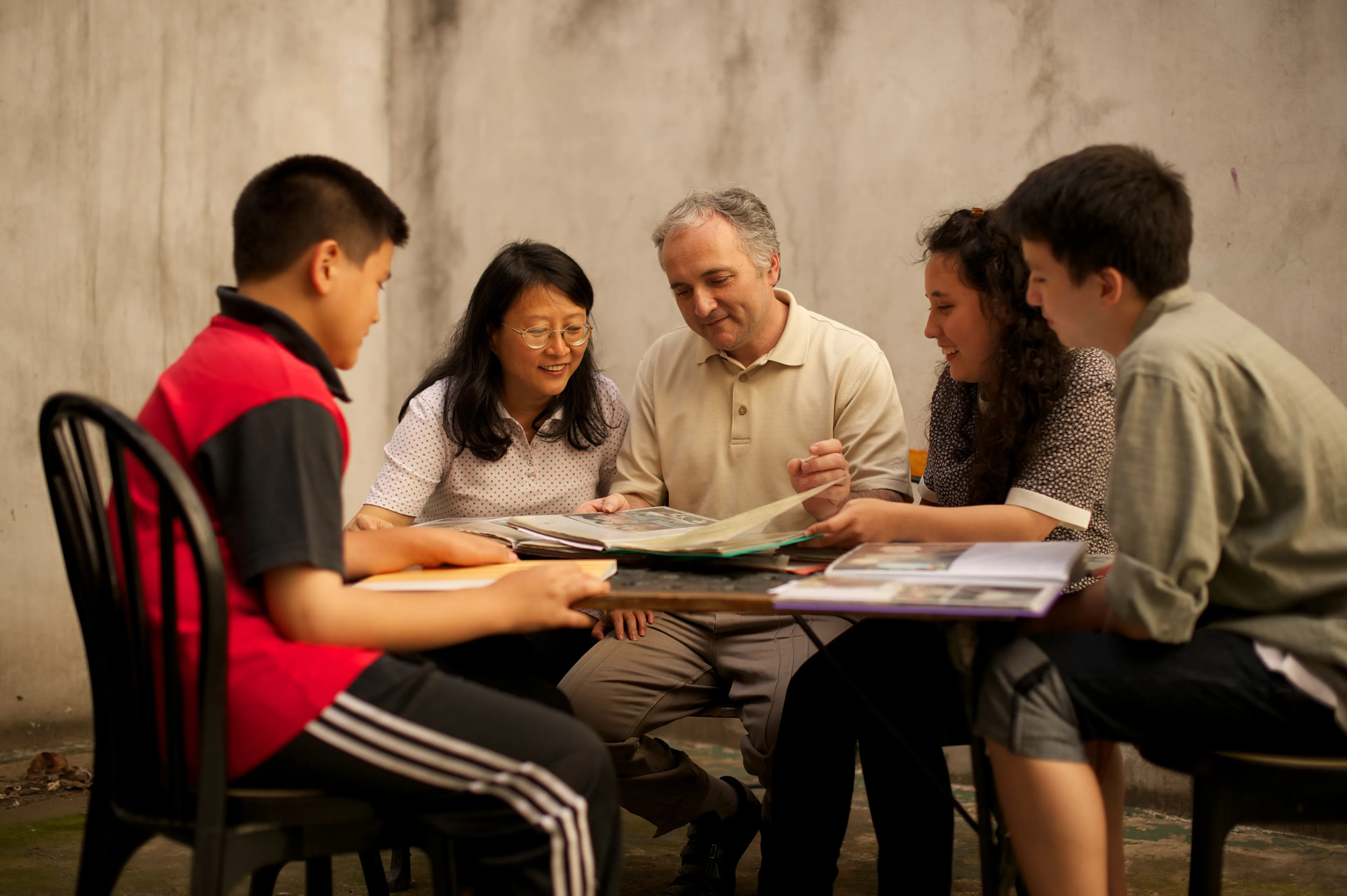 A family from Argentina sitting and looking through family history documents.