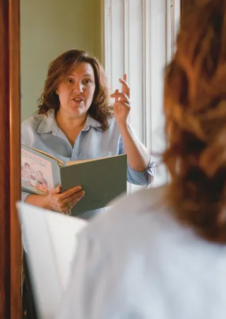 woman leading singing in front of mirror