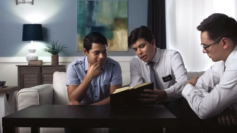 Missionaries reading the Bible with someone in their home