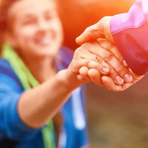 two people reaching out and holding hands