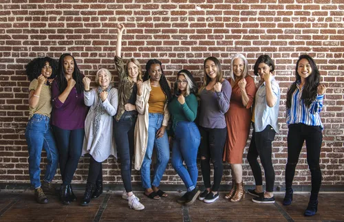 group of women standing by brick wall