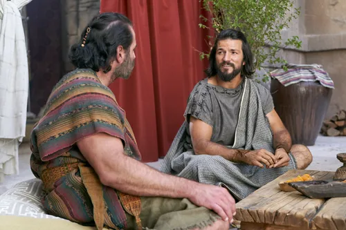 Alma the Younger sits and speaks with Amulek outside the house of Amulek in the city of Ammonihah.