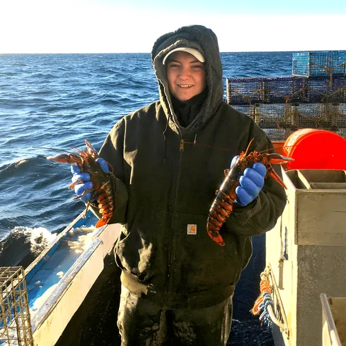 young man holding lobsters
