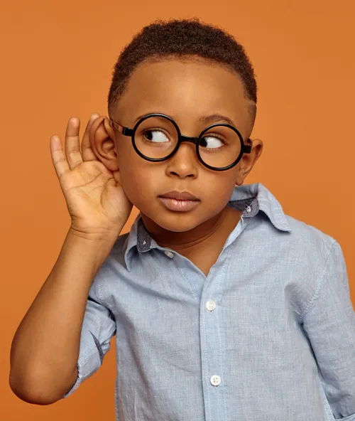 Boy with hand cupped around ear
