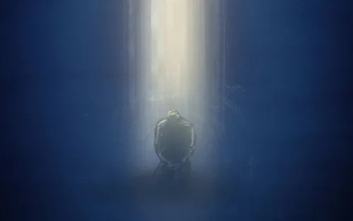 A man kneels in prayer as a column of light descends from heaven onto him