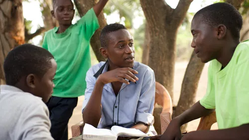 a young man sharing the scriptures with others