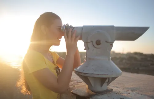 woman looking through a telescope