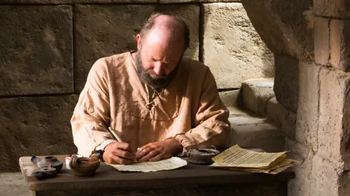 Paul sitting at a desk and writing
