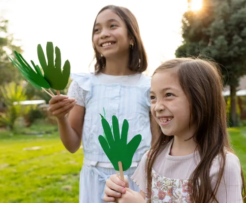 Image of two girls with paper palm branches