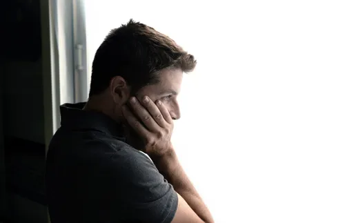 man looking out window