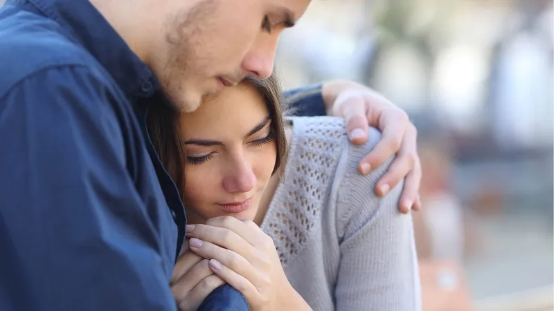 A man comforts his wife exemplifying blessed are they that mourn