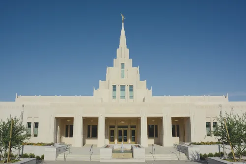 A view of the Phoenix Arizona Temple entrance and spire during the day, including scenery.