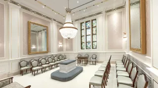 Winnipeg Manitoba Temple. An interior image of the temple featuring the Sealing Room. There are chairs around an altar. Above the altar is a chandelier. There is a stained glass window on one side. 