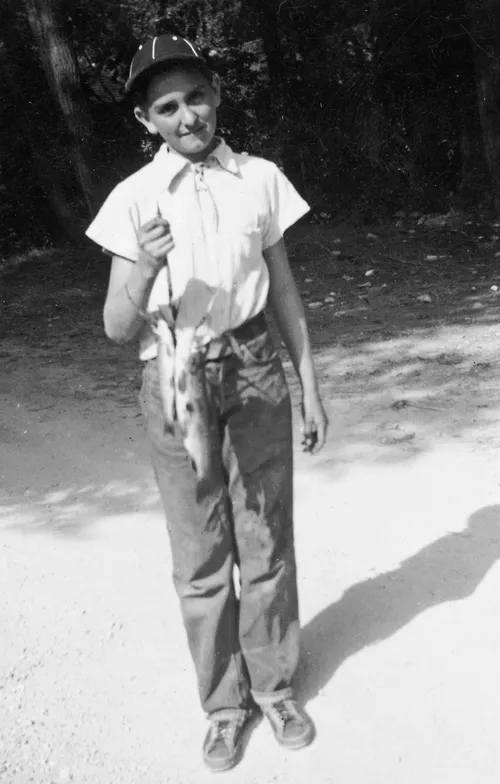 young Tom Monson holding fish