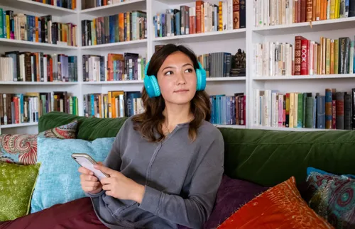 a woman wearing headphones sitting on a couch