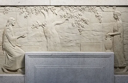 sculpted stone panel depicting Jesus and the Samaritan woman