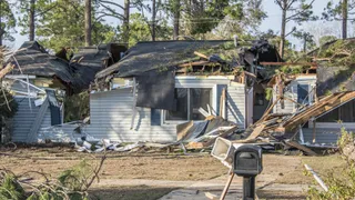 House with roof damage, tree branches, and debris as result from tornado on Jan 22, 2017 in Albany, Georgia. (horiz)