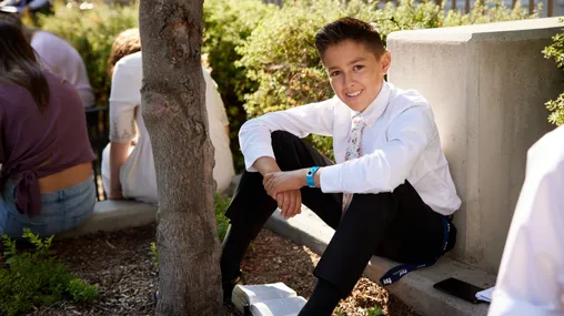 Various youth sit outside on the BYU campus reading scriptures and talking with each other. They are participating in FSY (EFY). 
