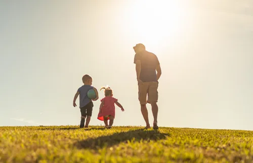a father running with two children
