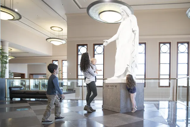 Children look at the Christus statue in the Conference Center.