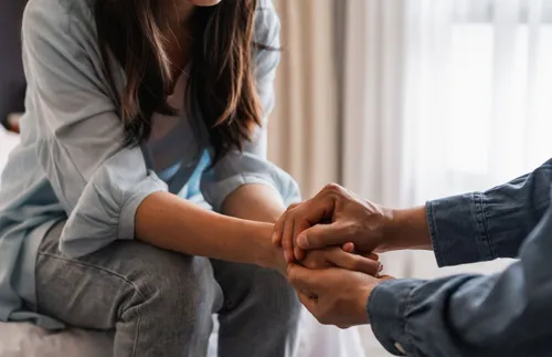 man and woman clasping hands