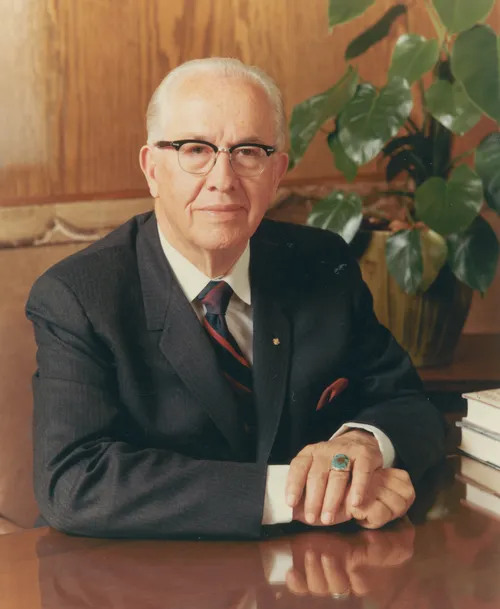 A portrait photograph by Eldon Keith Linschoten of Ezra Taft Benson sitting at a table.