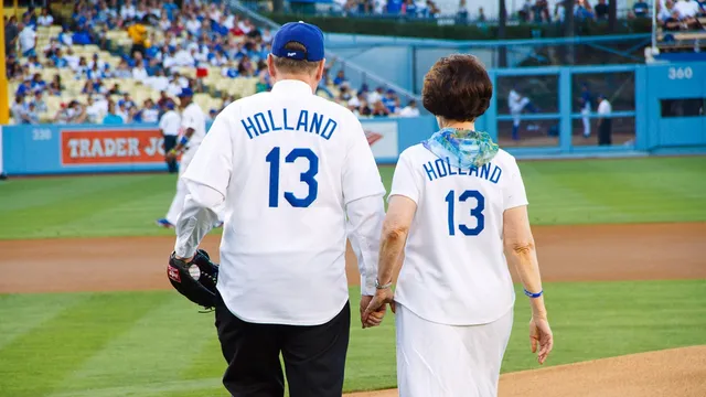 Elder and Sister Holland walk onto the pitcher's diamond at Dodger Stadium in Los Angeles, California, on June 28, 2013, prior to his ceremonial first pitch to begin the game.