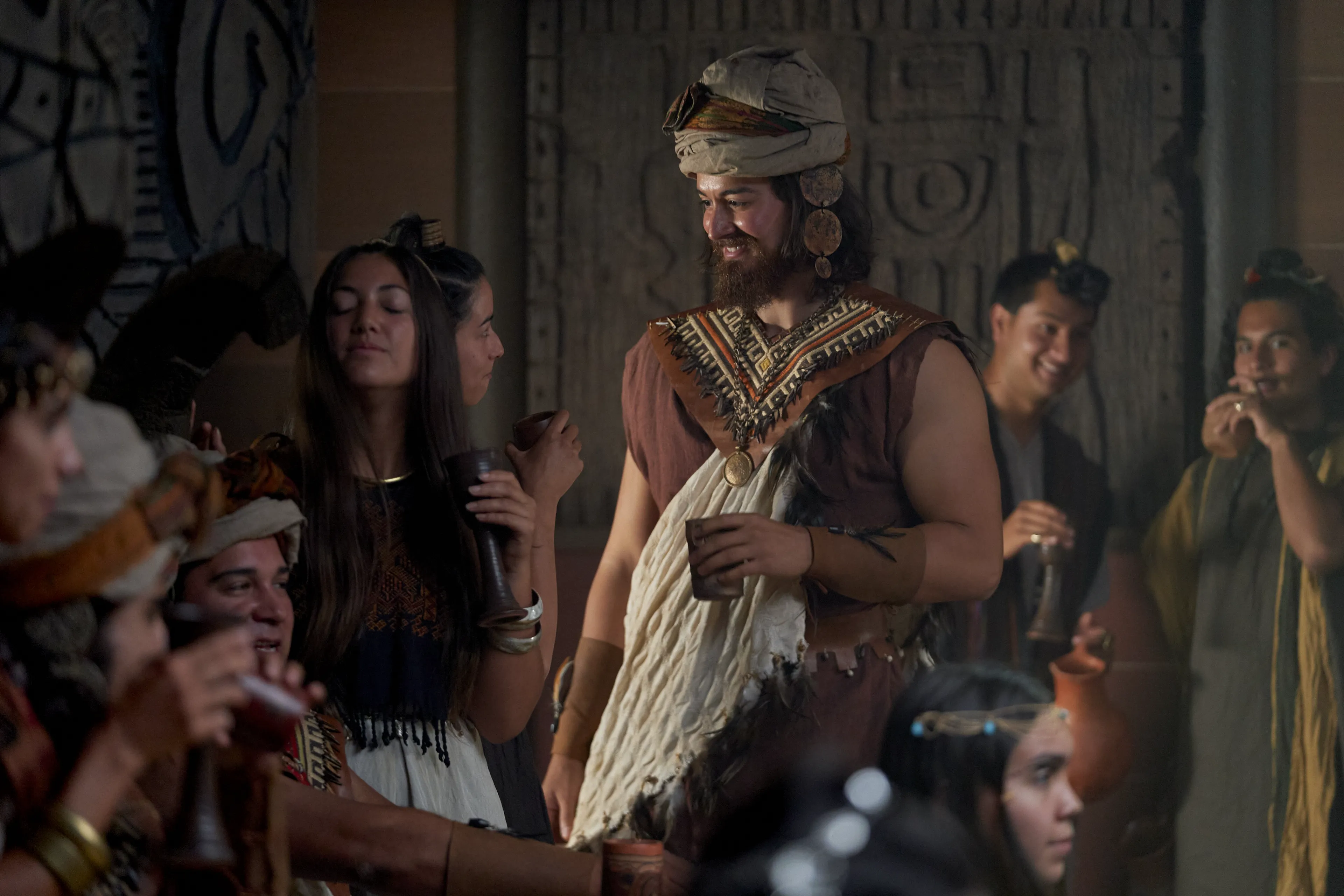 Alma feasts in King Noah’s throne room. He is surrounded by priests and women.