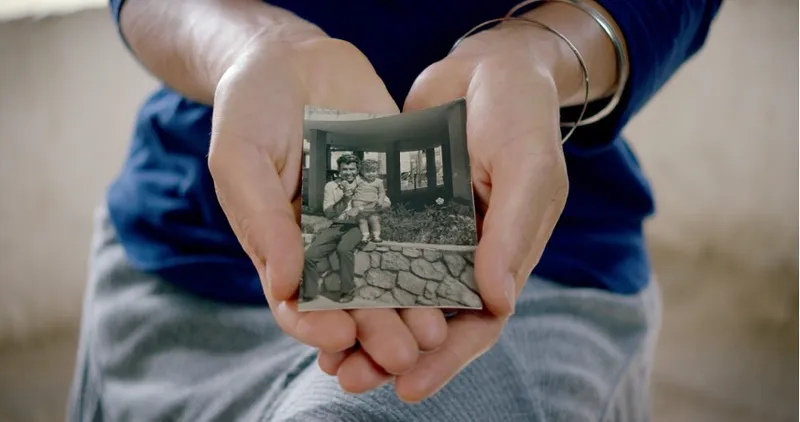 A woman holds a picture of her ancestor