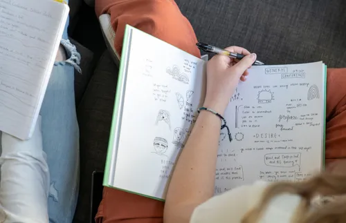 a woman with a notebook full of notes and doodles