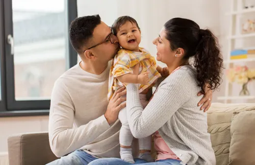 parents smiling at a laughing baby