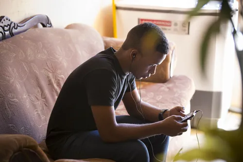 young man sitting on a couch with a phone