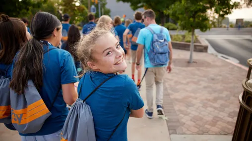 Various youth are together on the BYU campus reading scriptures, talking, listening to speakers, and playing games. They are participating in FSY (EFY). 