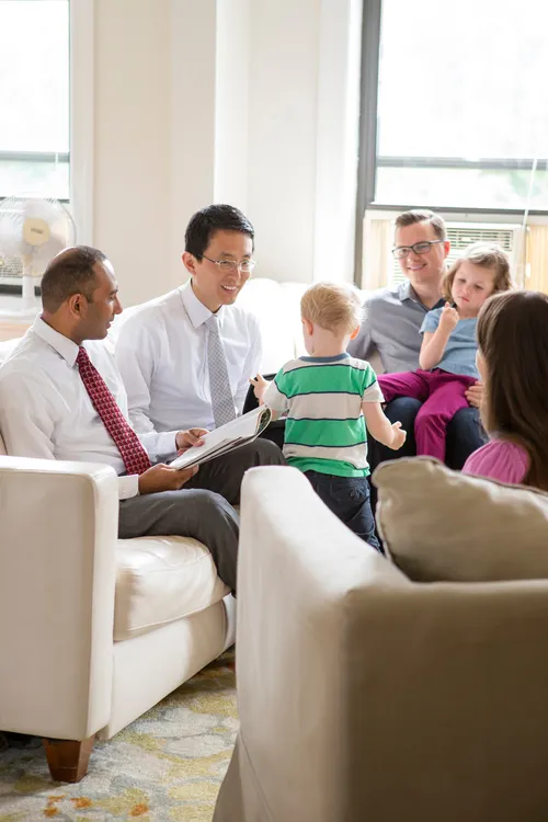 men visiting couple and two small children