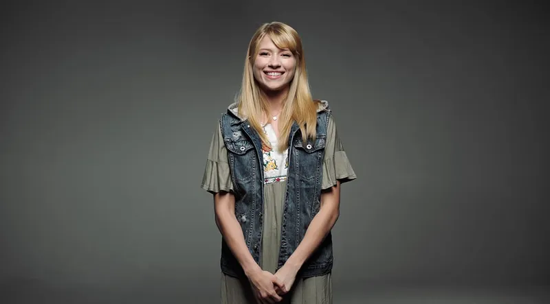 A woman smiling explains beliefs of the Church of Jesus Christ of Latter-day Saints
