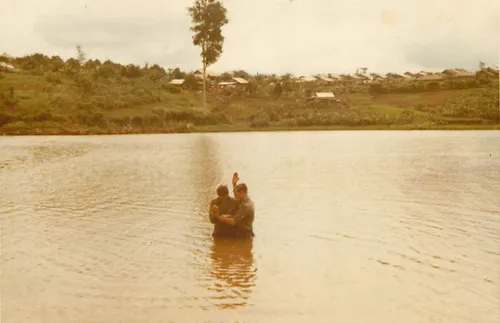 man being baptized in a lake