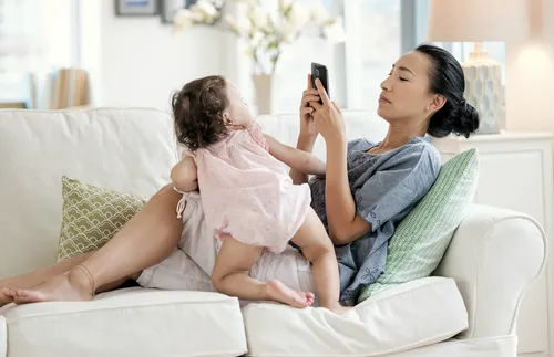 woman with baby looking at phone