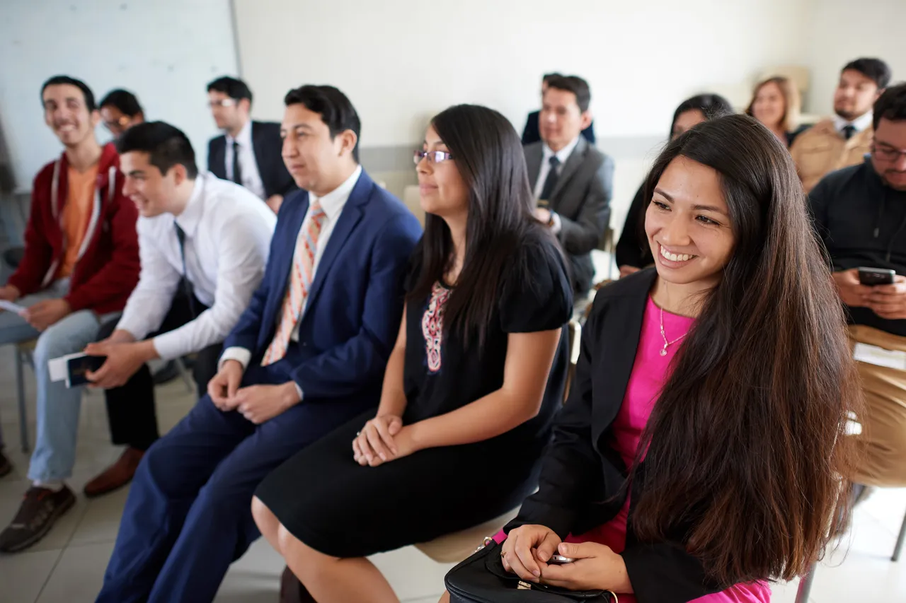 A family sit together during a church meeting enjoying the blessings of Jesus Christ