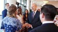 Worldwide Devotionals for Young Adults poster shots with Elder Nelson Shaking hands with young adults, laughing and smiling.